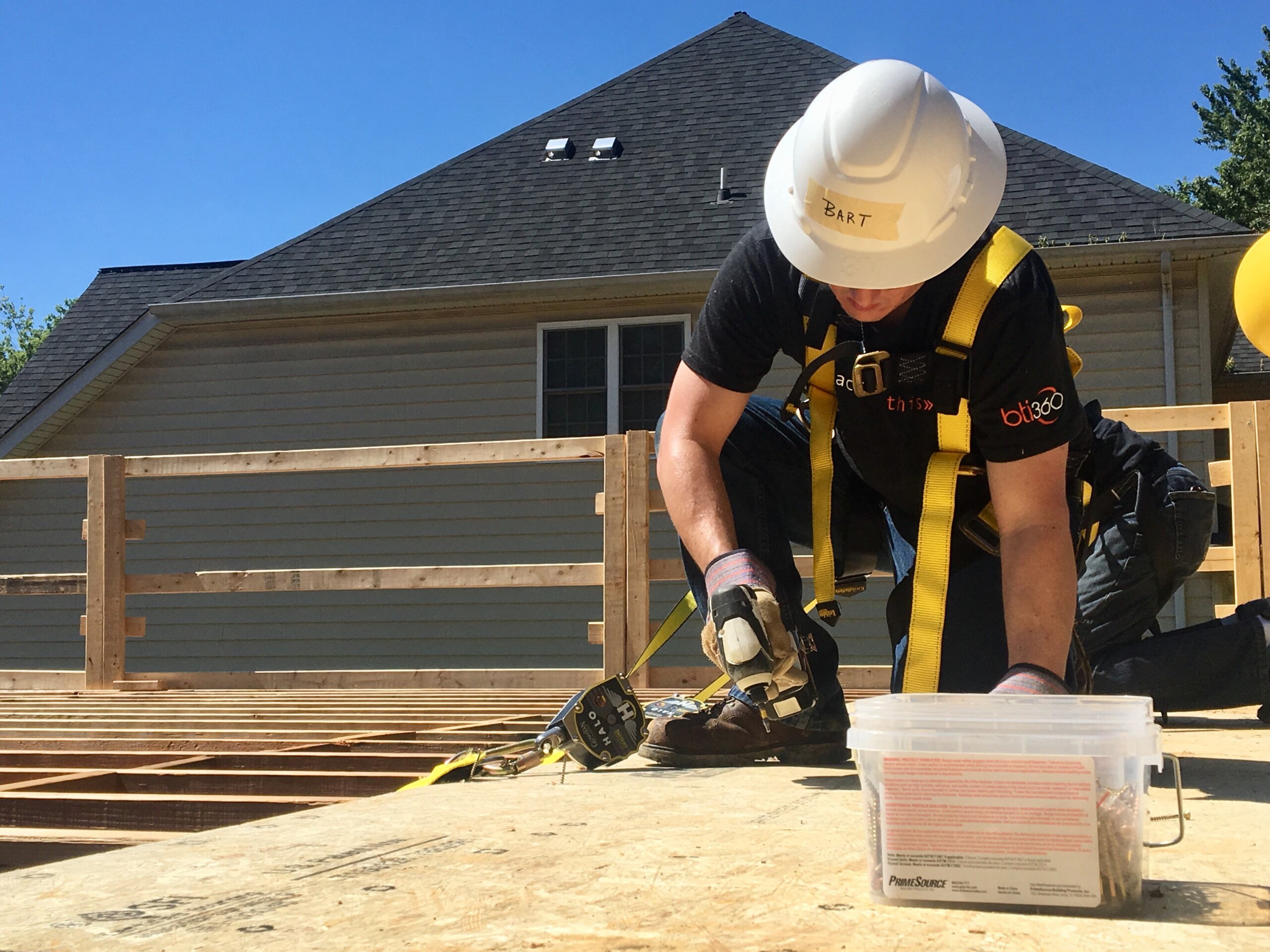 Person in safety gear building on wooden structure