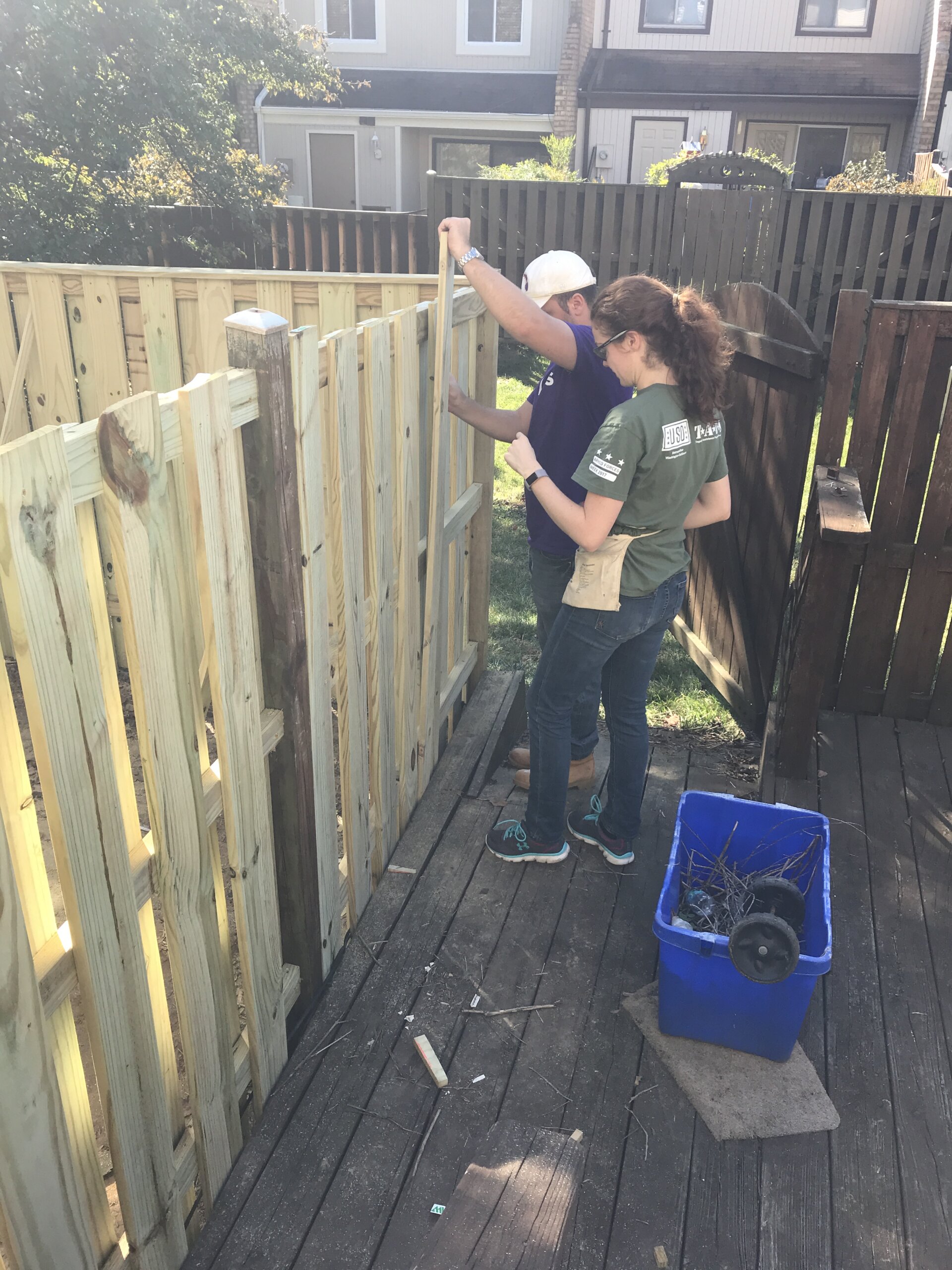 two individuals building a fence