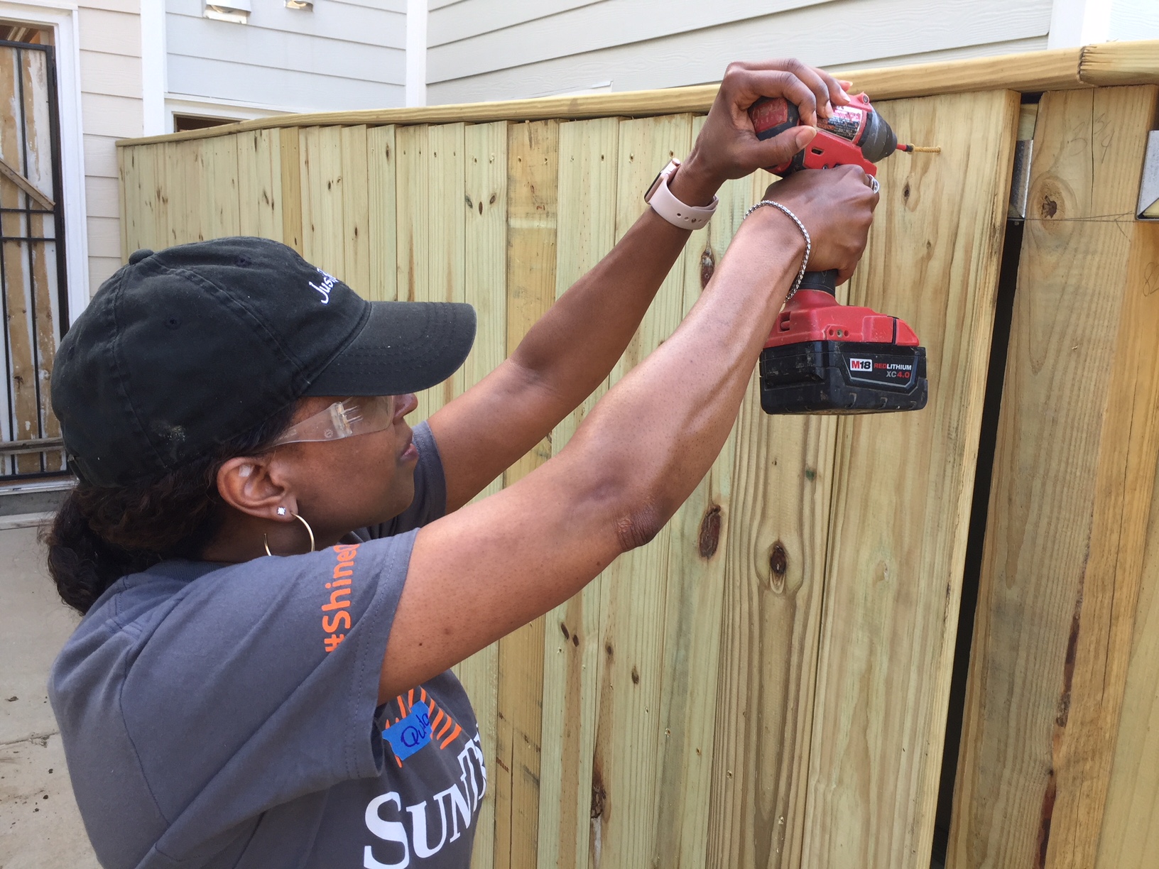 Woman drilling a fence