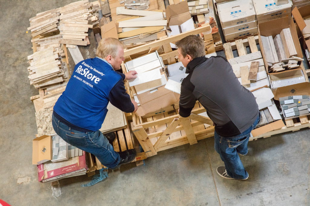 Two people handling materials and boxes on the ground