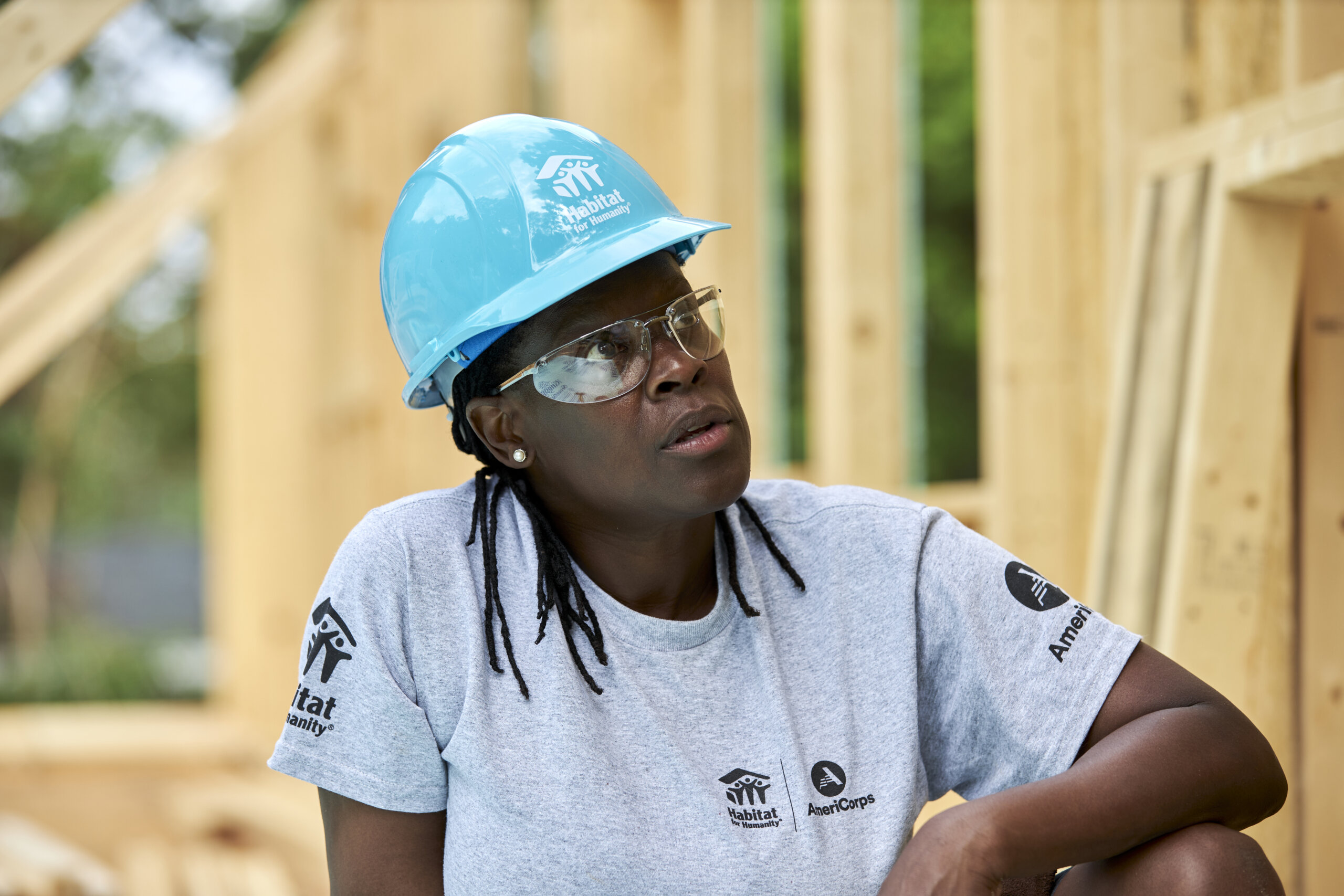 AmeriCorps member sitting on a construction site
