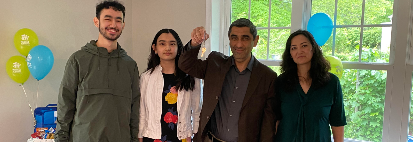 Family of four holding keys to their new home