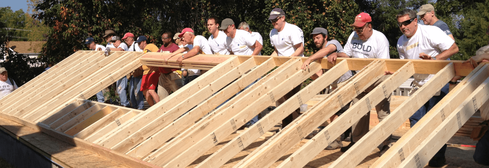 Volunteers lifting a wall together
