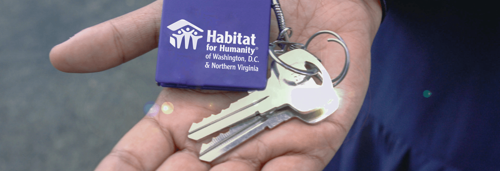 a hand holding keys and a purple icon that reads "Habitat for Humanity of Washington, D.C. & Northern Virginia"