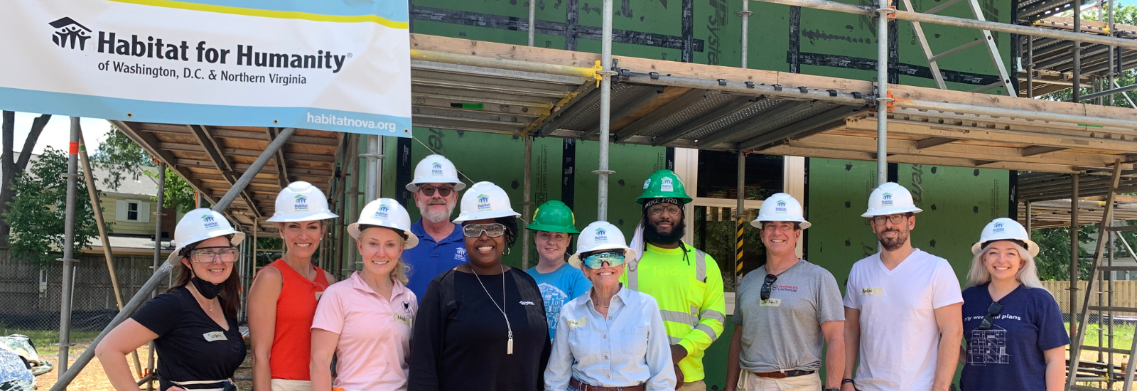 Group of several individuals wearing white hardhats smiling at the camera